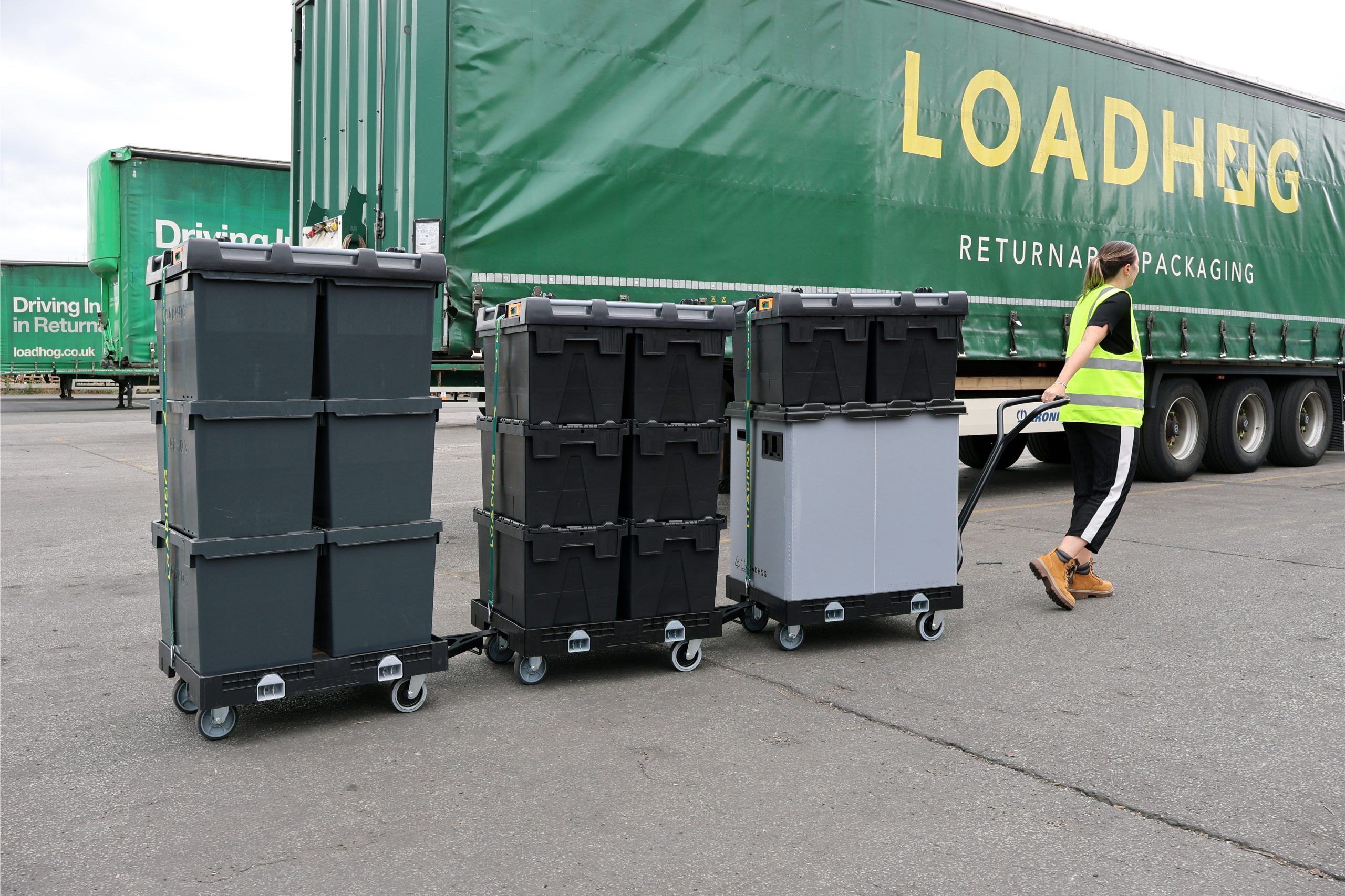 Warehouse operator pulling a train of wheeled containers